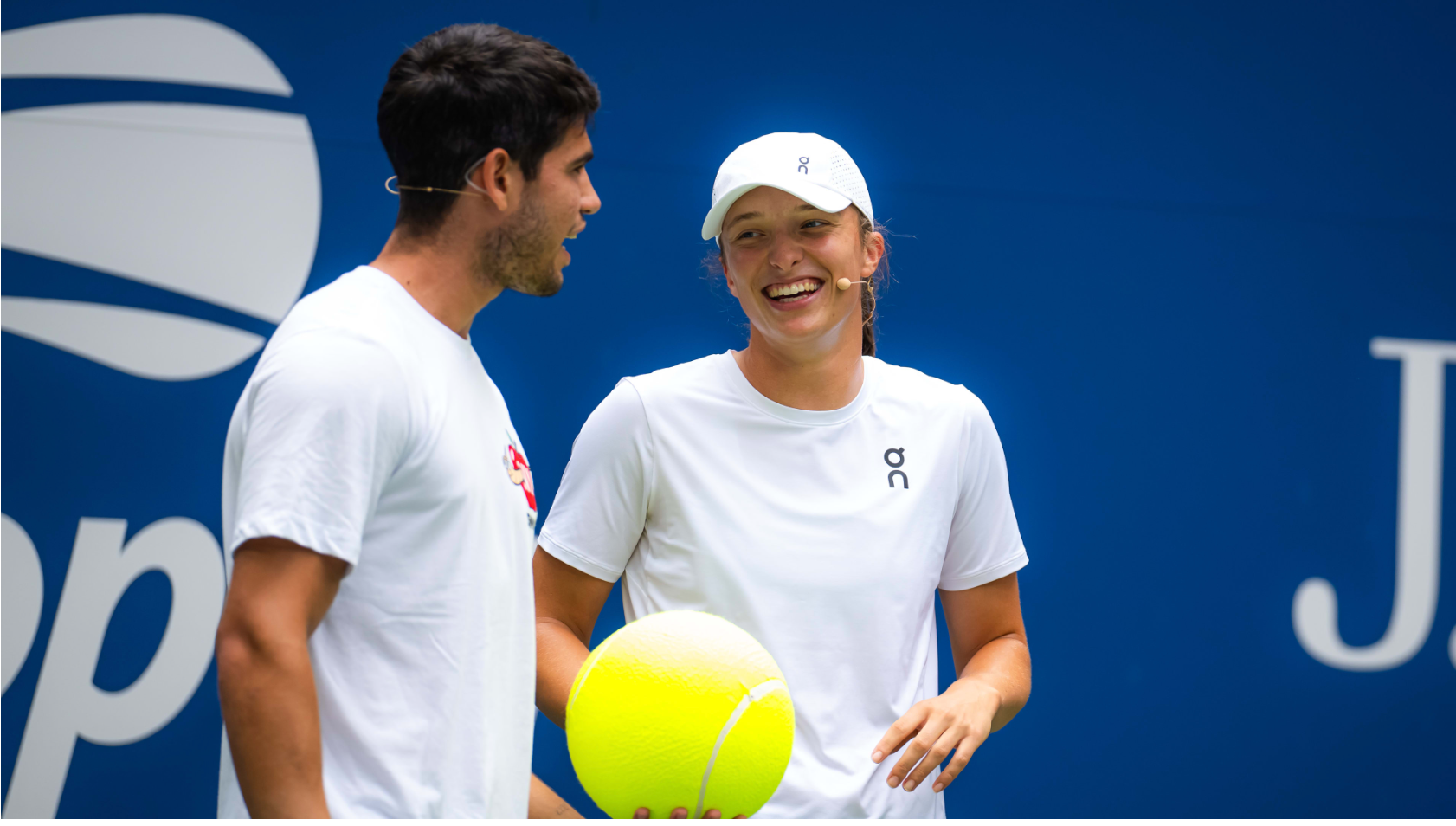Two tennis players sharing a light moment on the court.
