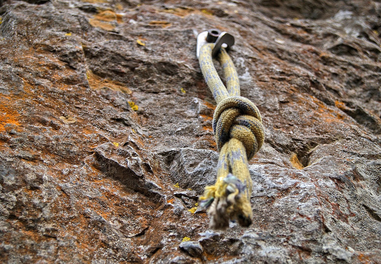 knot-symbol-belief-faith-trust Photo of knot hammered into rock to aid mountain climbing.