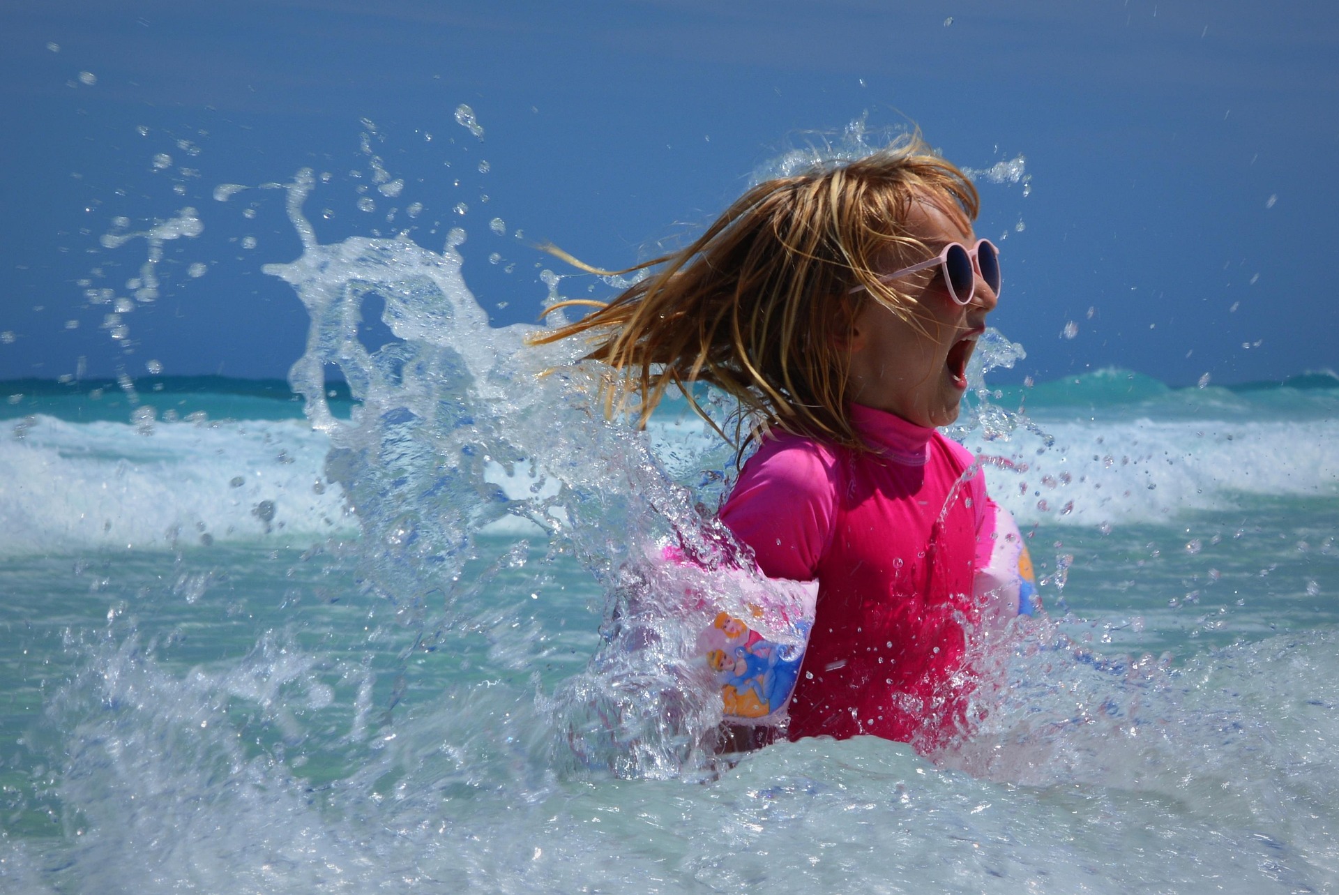Young girl joyful in splashing waves